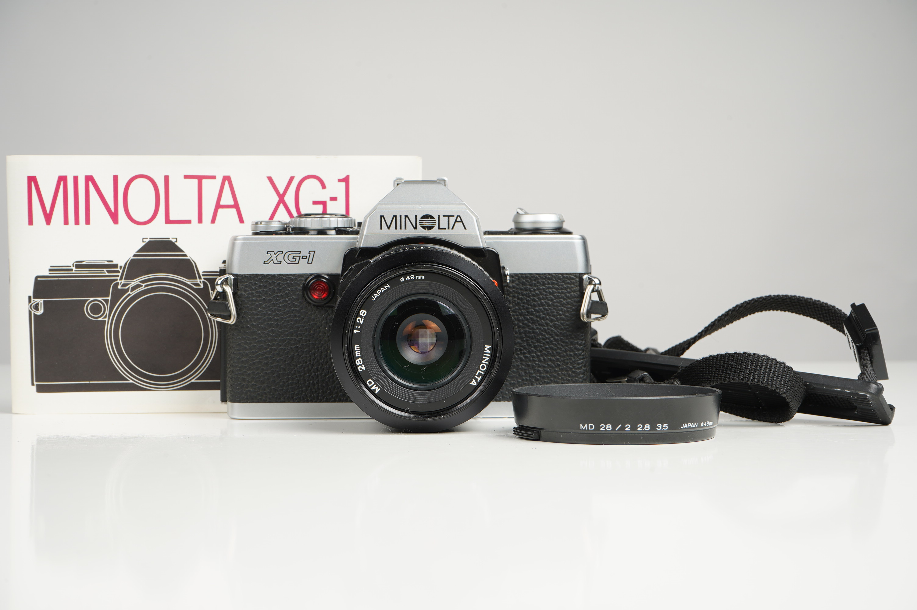 Gebraucht Minolta XG-1 + MD 28mm F2.8  | Gut erhalten - normale Gebrauchsspuren | inkl. Gegenlichtblende/Riemen/Betriebsanleitung |
